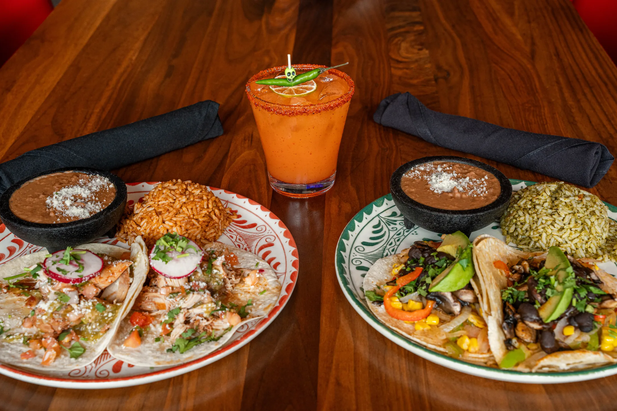 Tacos, sides and a margarita laid out on the table